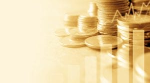 image of coins in the background with a bar graph and line graph overlaid on top. The image has a yellow hue